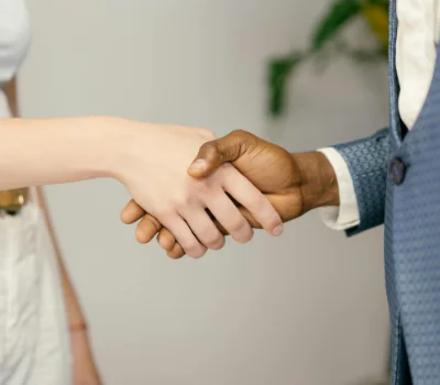 Uma aperto de mãos entre uma mulher branca e um homem negro